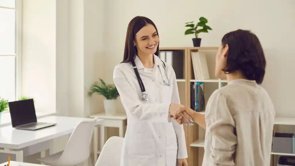 Doctor shaking hands with patient in medical office – highlighting trust and conversion-focused healthcare website design by a healthcare SEO agency