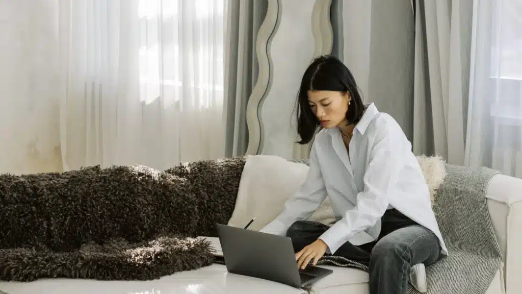 A woman sits in a medspa, focused on her laptop. The environment suggests a luxury clinical setting dedicated to wellness. This visual supports topics related to email marketing for medspas, including managed email marketing, customer journey strategy, and email marketing lead generation.