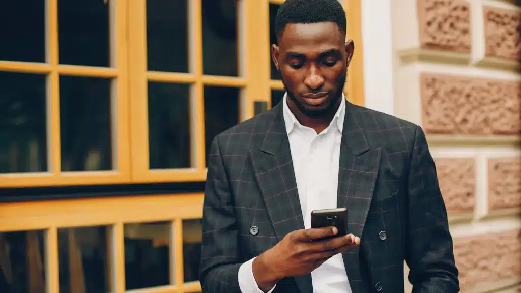 A man scrolls on his smartphone, focused on the screen. Visual represents user experience, mobile-first design, and the importance of custom website development services, SEO web page design, and modern website design for healthcare and small business brands.