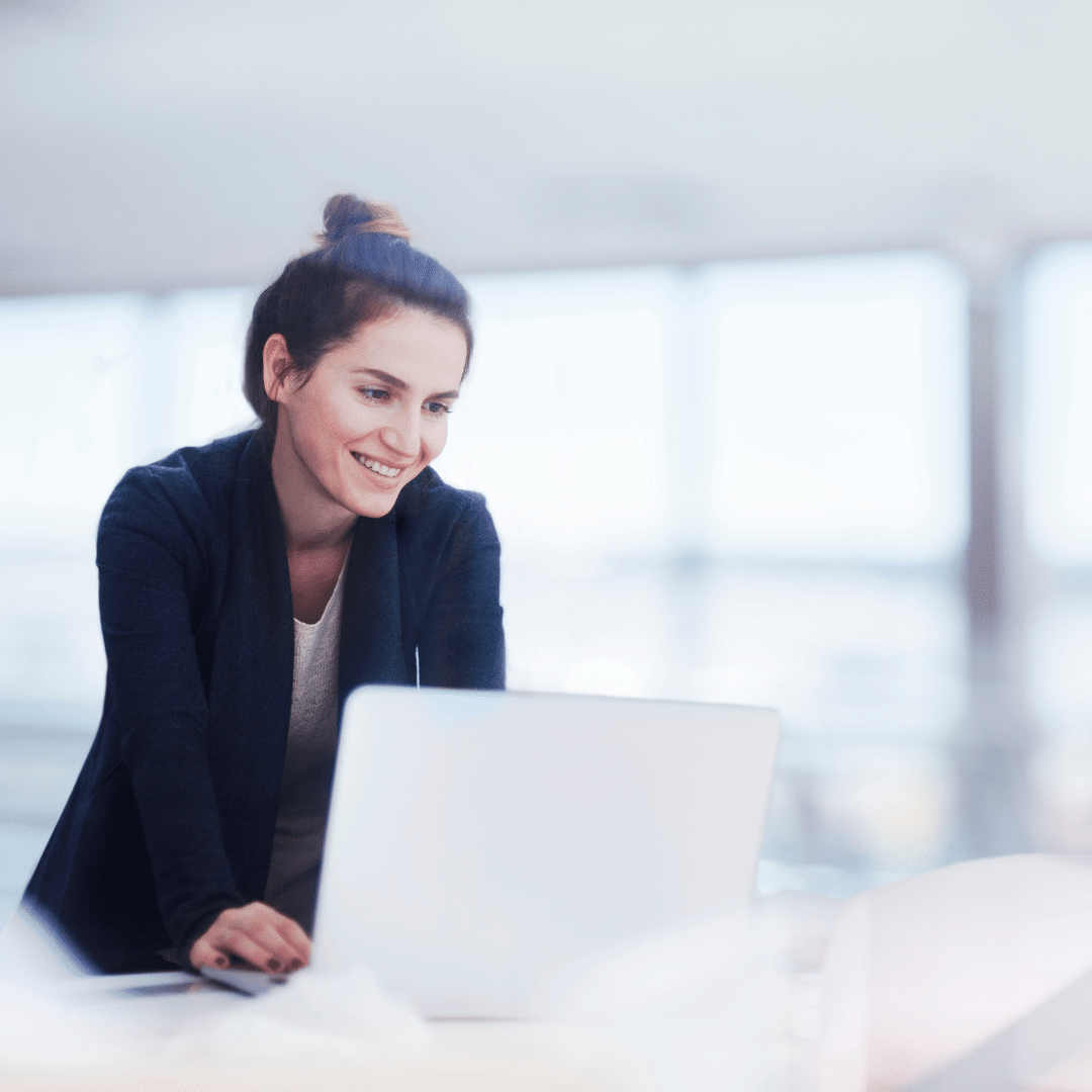 Smiling woman at her computer about to type, representing digital marketing for chiropractors and client engagement.