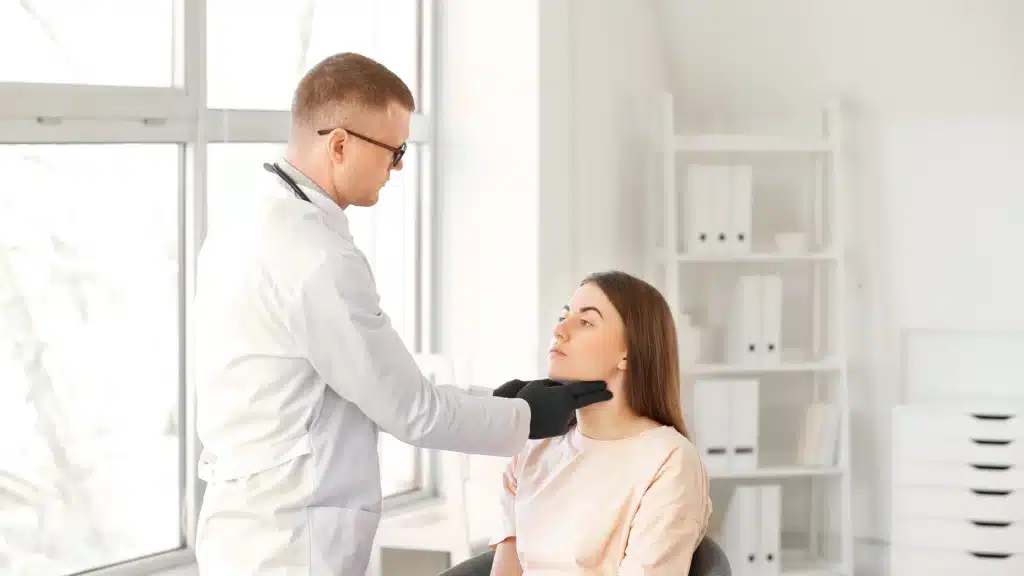 Doctor examines a patient’s lymph nodes during a checkup, representing HIPAA compliance and protected health information in healthcare SEO.
