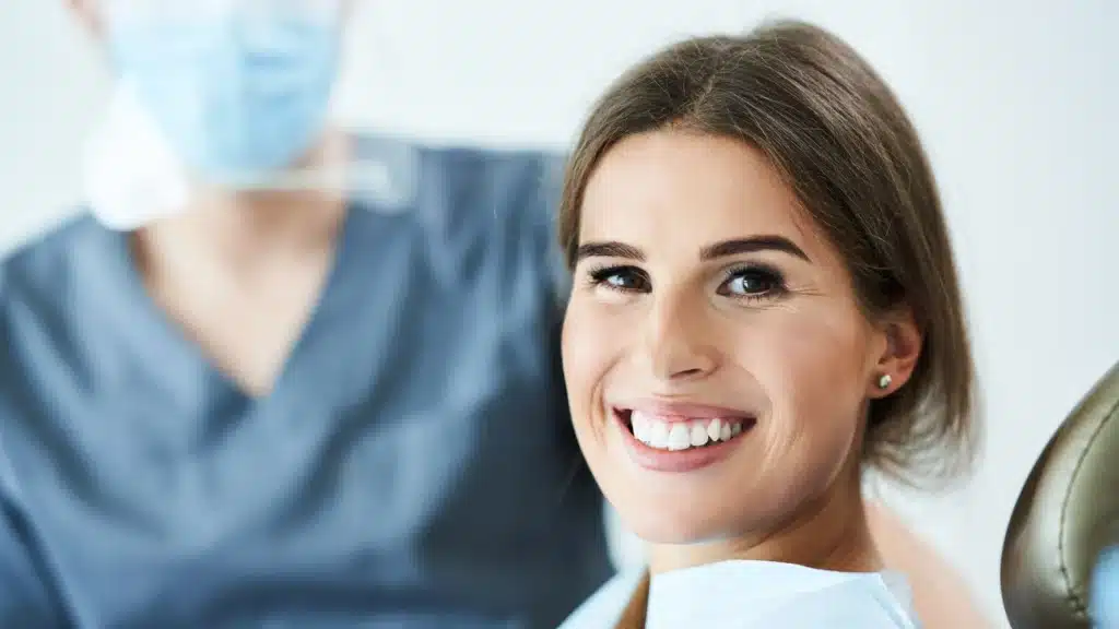 A woman in a luxury dentist office smiles showing the importance of patient trust.